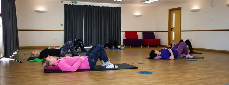 Pilates instructor guiding a client through tailored exercises to improve back pain and sports performance in Broadstone.