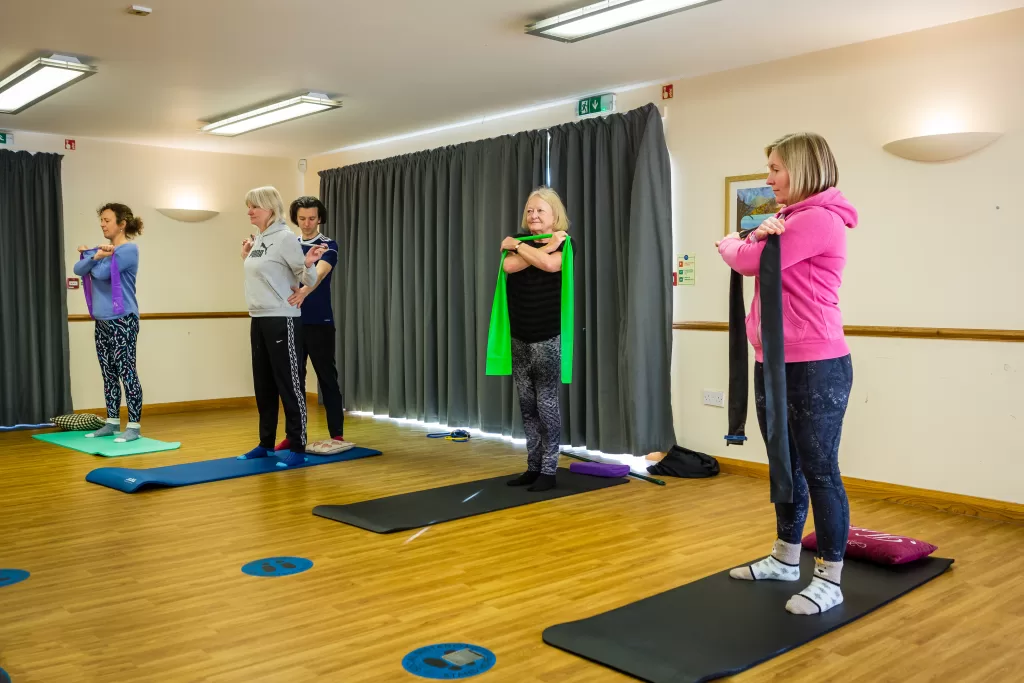 Small group Pilates in Broadstone. Performing exercises in a standing position.