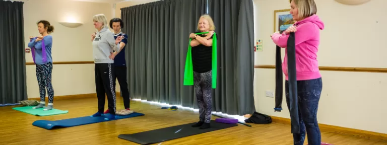 Small group Pilates in Broadstone. Performing exercises in a standing position.