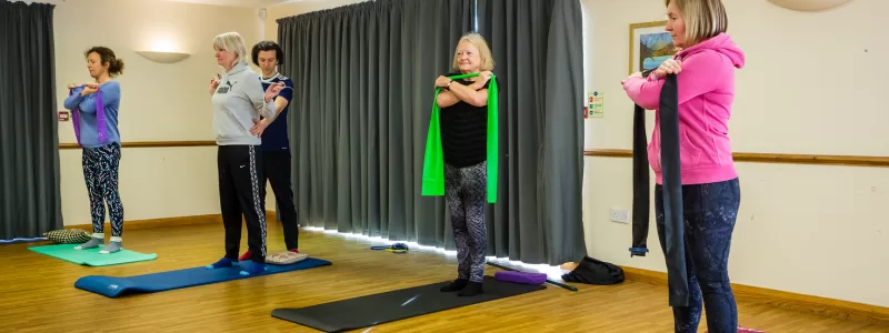 Small group Pilates in Broadstone. Performing exercises in a standing position.
