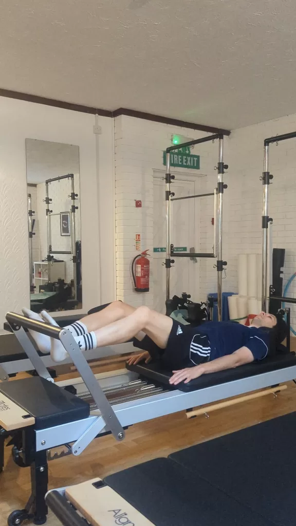Client using a Pilates reformer during a small group class in Broadstone near Wimborne