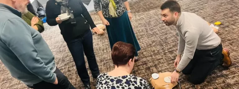 People attending a first aid training course in Poole, Dorset, practicing CPR and emergency response techniques