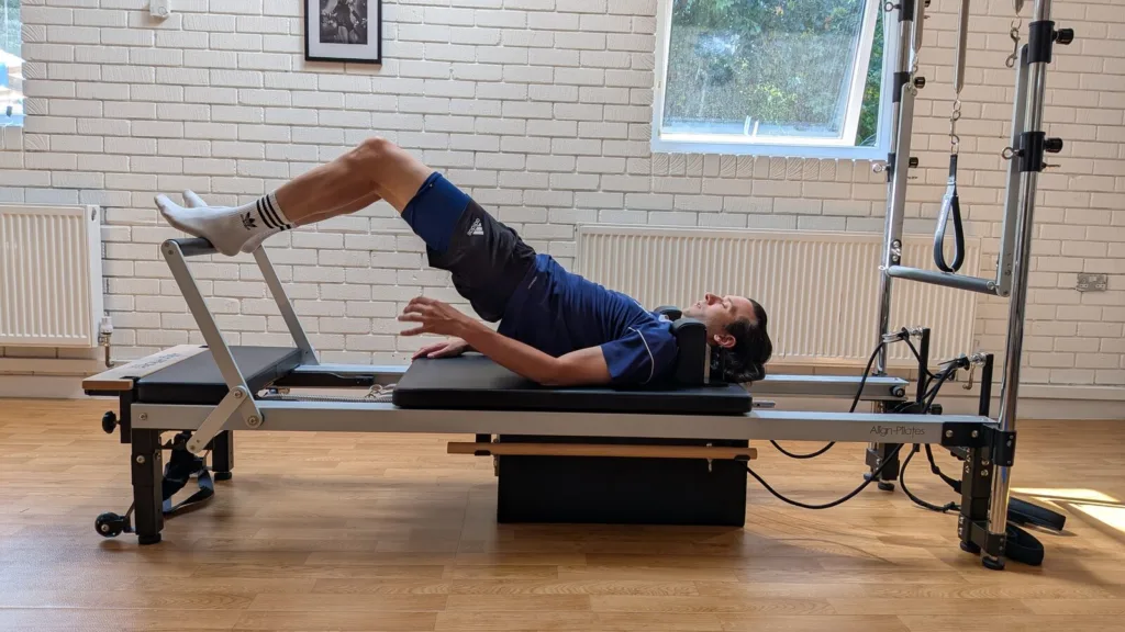 Client performing a bridge on the Reformer as part of hamstring rehab at Thrive Studio Broadstone.