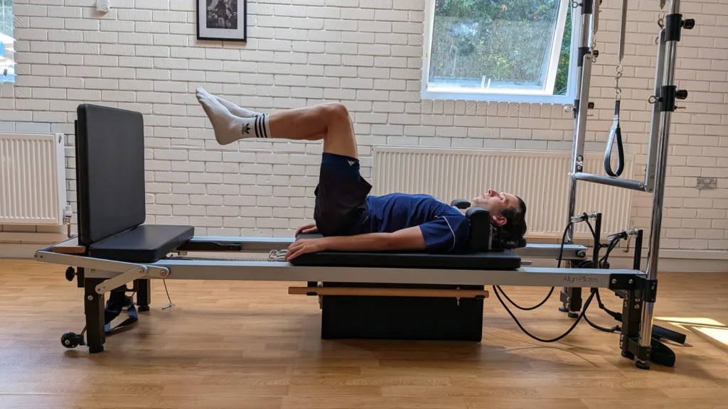 Client performing jumpboard exercise on the Reformer for hamstring tendinopathy return-to-sport phase in Broadstone