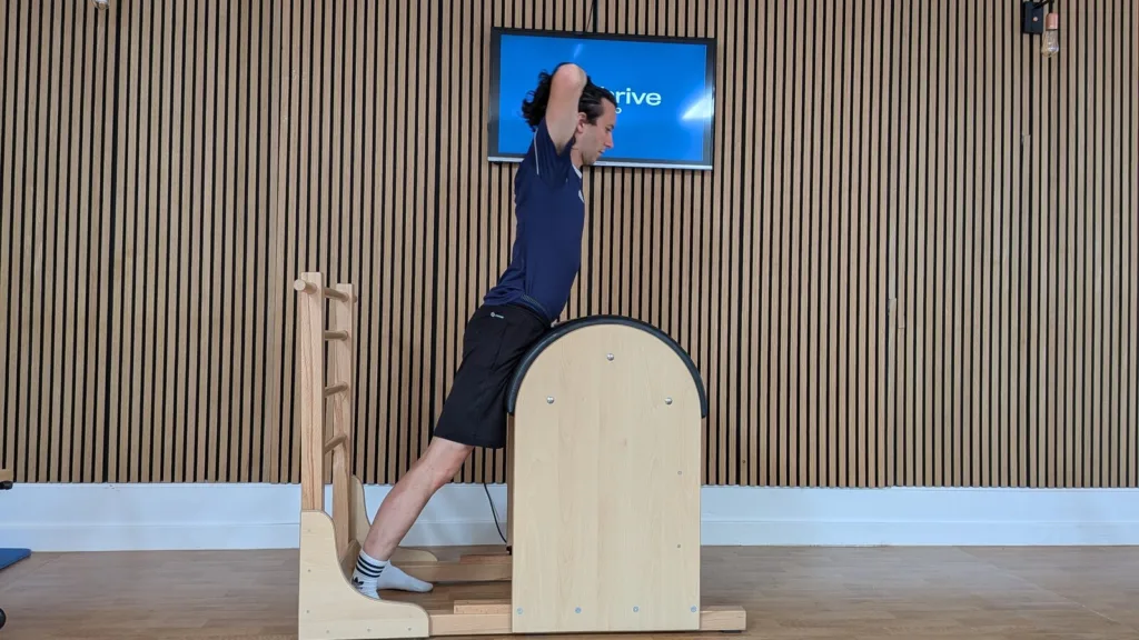 Client performing a ladder barrel extension hold for hamstring tendinopathy rehab at Thrive Studio Broadstone